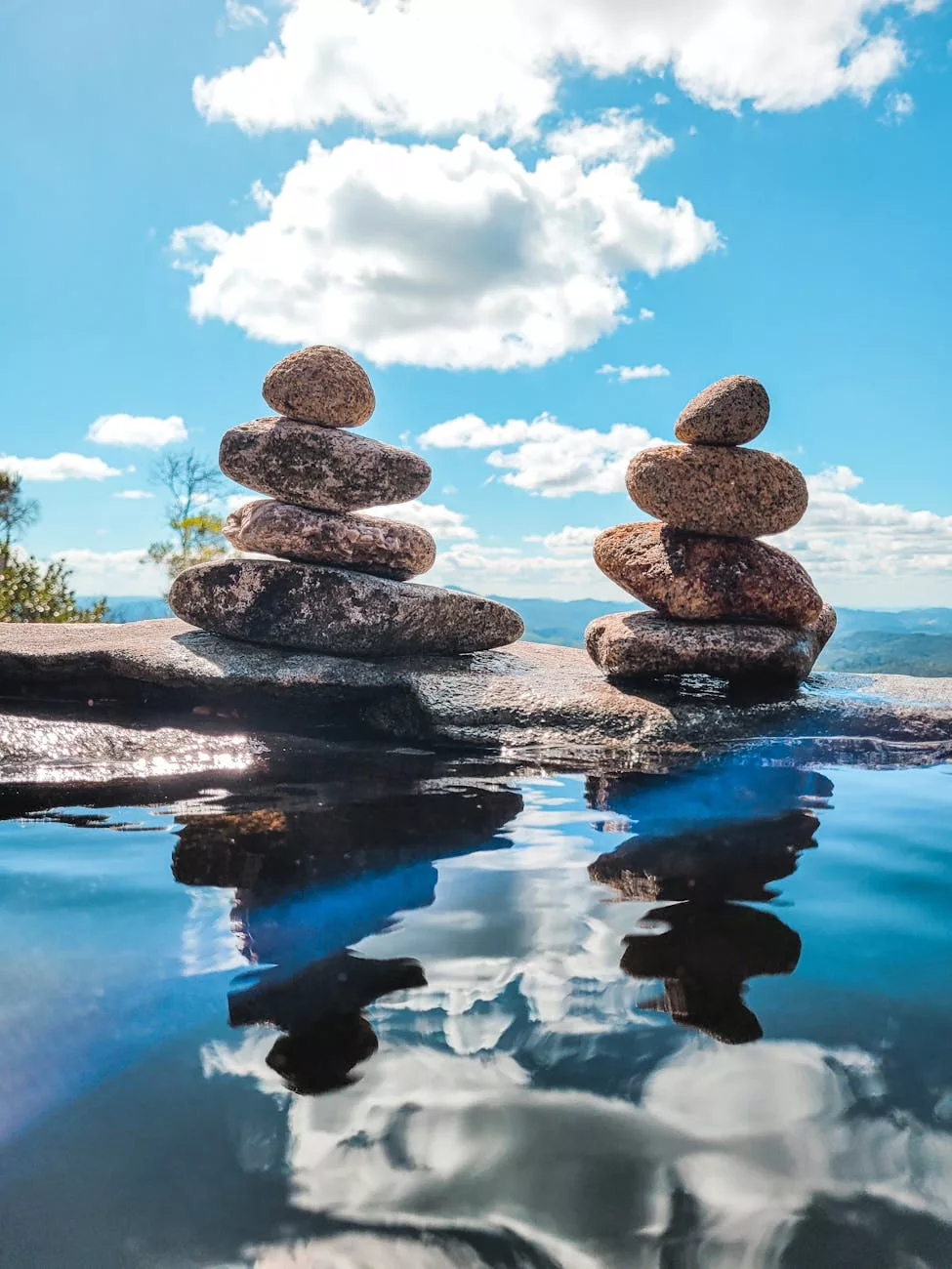 peaceful stone cairns reflecting in water