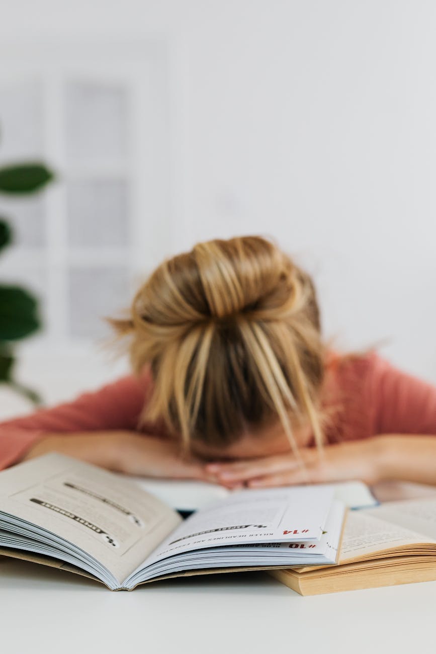 woman lying on table with books